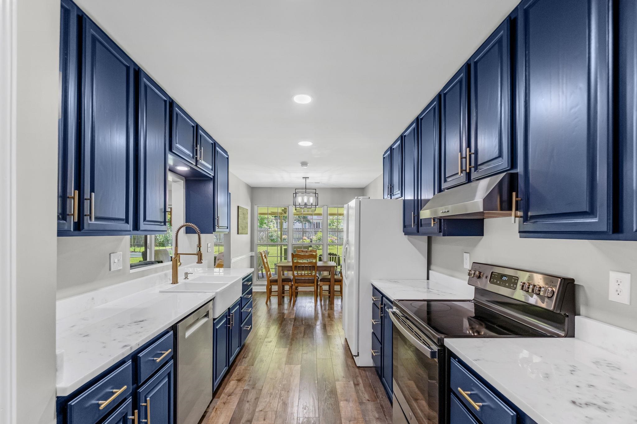 4729 Cedar Ridge Drive Millington, TN 38053 - Photo 9 of 40 Galley kitchen featuring navy cabinetry with brass hardware, white countertops, wood-finish flooring, and recessed lighting