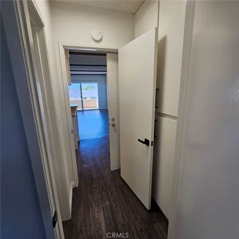 a view of a hallway with wooden floor and closet