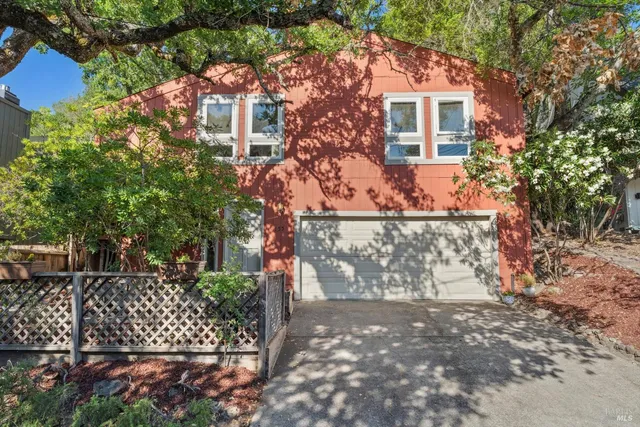 a front view of a house with a tree