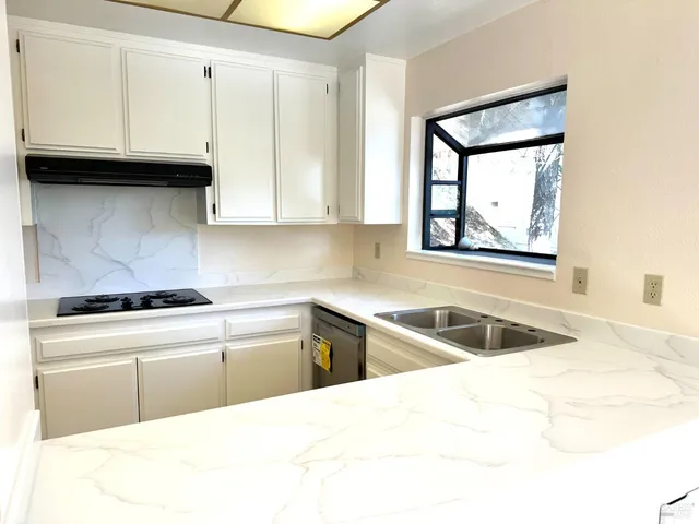 a bathroom with a granite countertop sink a toilet a mirror and shower