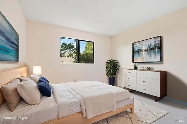 a bedroom with a white bed and a dresser