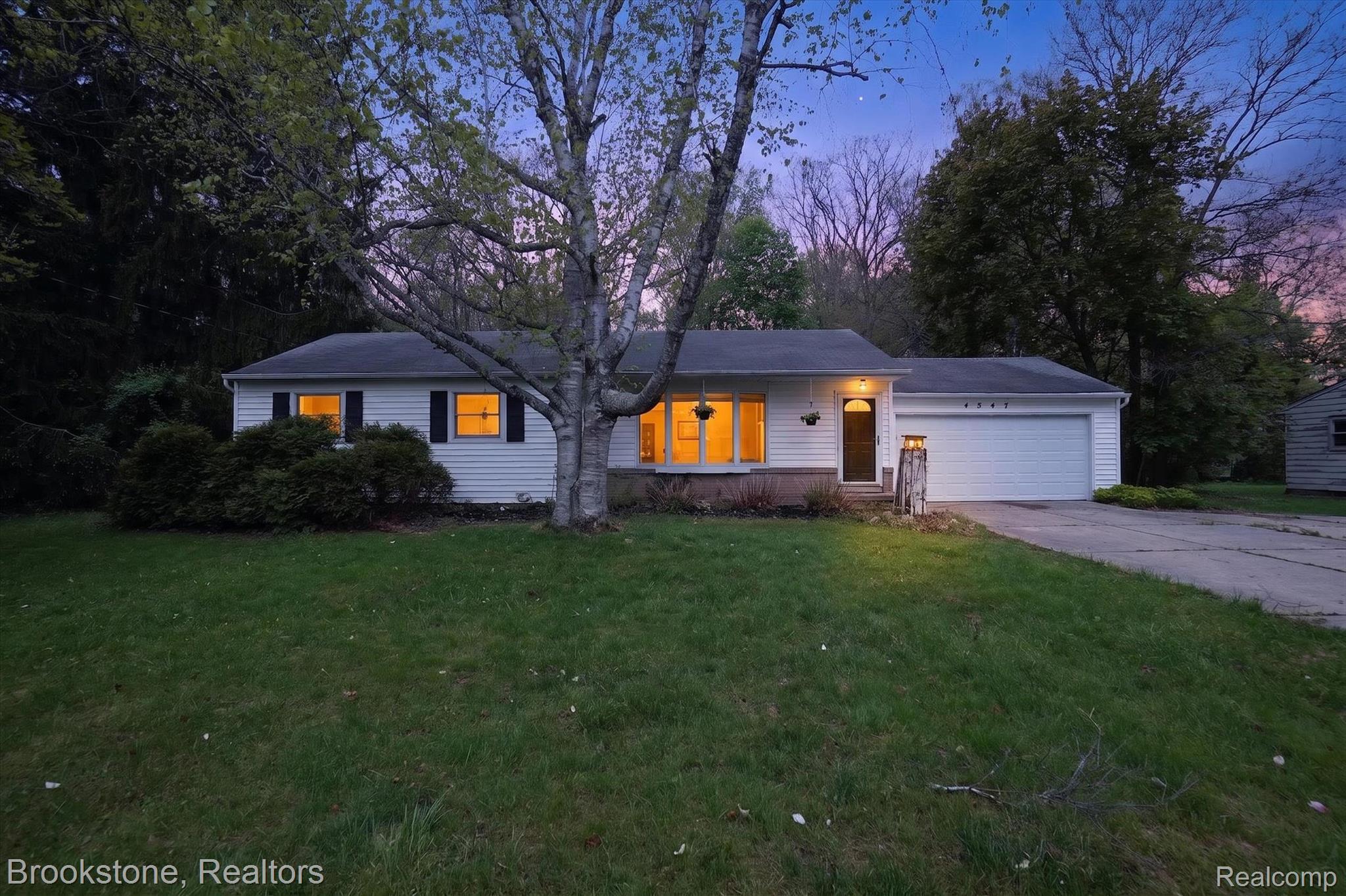 4547 Marlborough Road Okemos, MI 48864 - Photo 1 of 55 Ranch-style home featuring covered porch, a lawn, a garage, and concrete driveway
