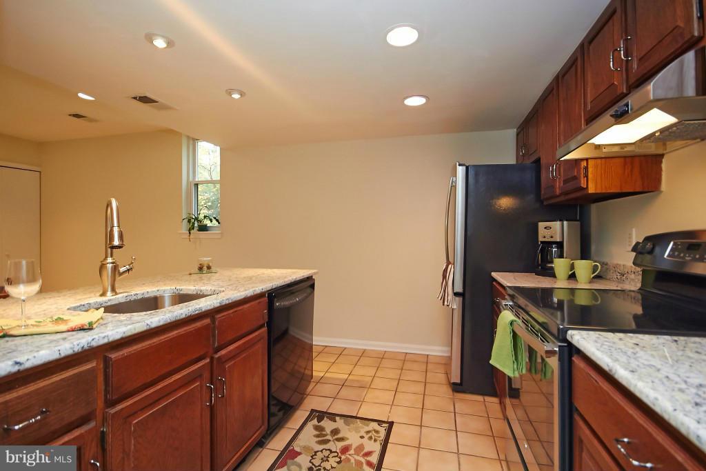 11008 Saffold Way Reston, VA 20190 - Photo 8 of 24 a kitchen with a sink stove and cabinets