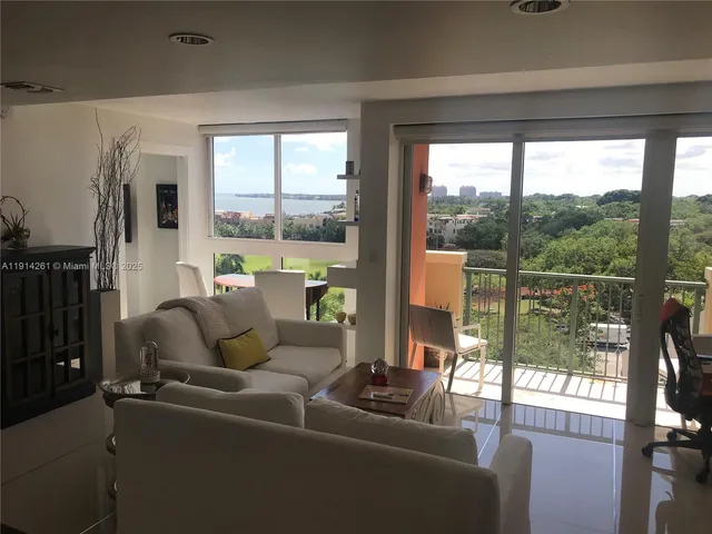 a living room with hardwood floor and large windows