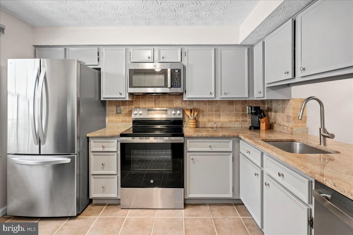 1642 Harvest Green Court Reston, VA 20194 - Photo 11 of 46 a kitchen with a refrigerator sink and cabinets
