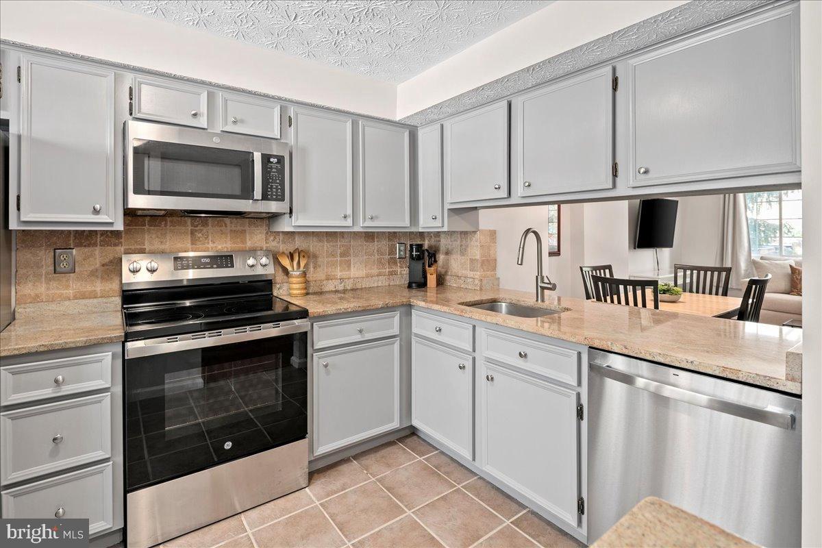 1642 Harvest Green Court Reston, VA 20194 - Photo 12 of 46 a kitchen with granite countertop white cabinets and stainless steel appliances