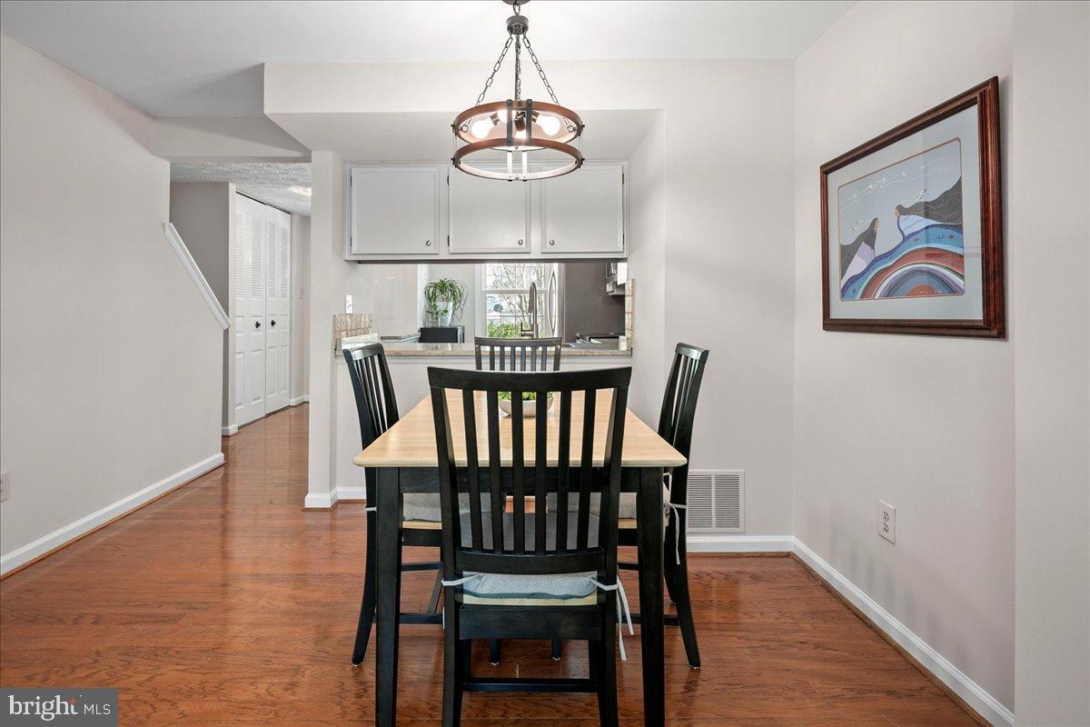 1642 Harvest Green Court Reston, VA 20194 - Photo 16 of 46 a view of a dining room with furniture wooden floor and chandelier