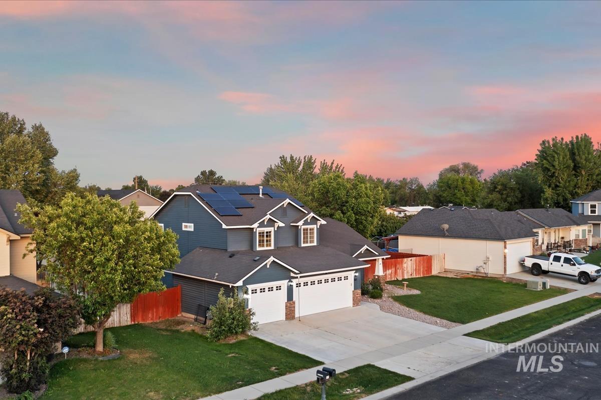 80 Cobblestone Court Middleton, ID 83644 - Photo 45 of 48 Two-story residence featuring a blue exterior with white trim, a three-car garage, and solar panels