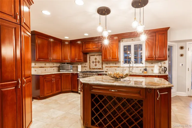 a kitchen with stainless steel appliances granite countertop a sink a stove and refrigerator
