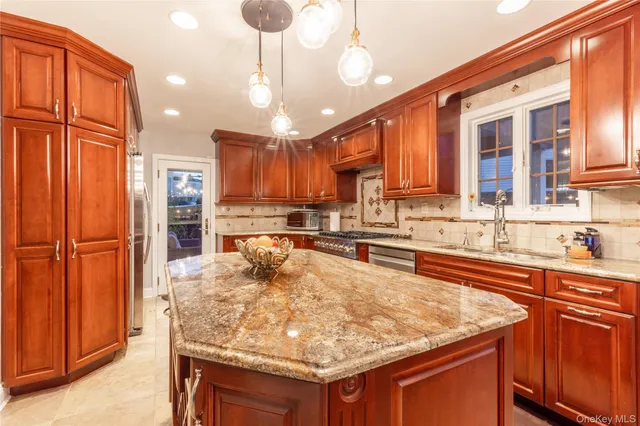 a kitchen with stainless steel appliances granite countertop a sink refrigerator and cabinets