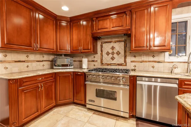 a kitchen with stainless steel appliances granite countertop a stove a sink and cabinets