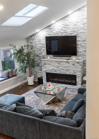 a living room with furniture a flat screen tv and a fireplace