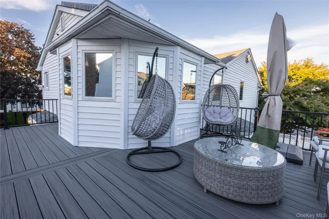 a view of a house with wooden deck furniture