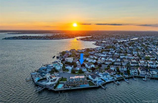 an aerial view of ocean and residential houses with outdoor space