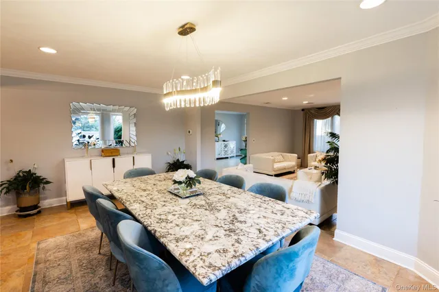 a dining room with wooden floor and chandelier