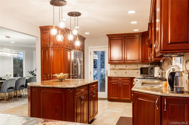 a kitchen with kitchen island granite countertop a sink cabinets and stainless steel appliances