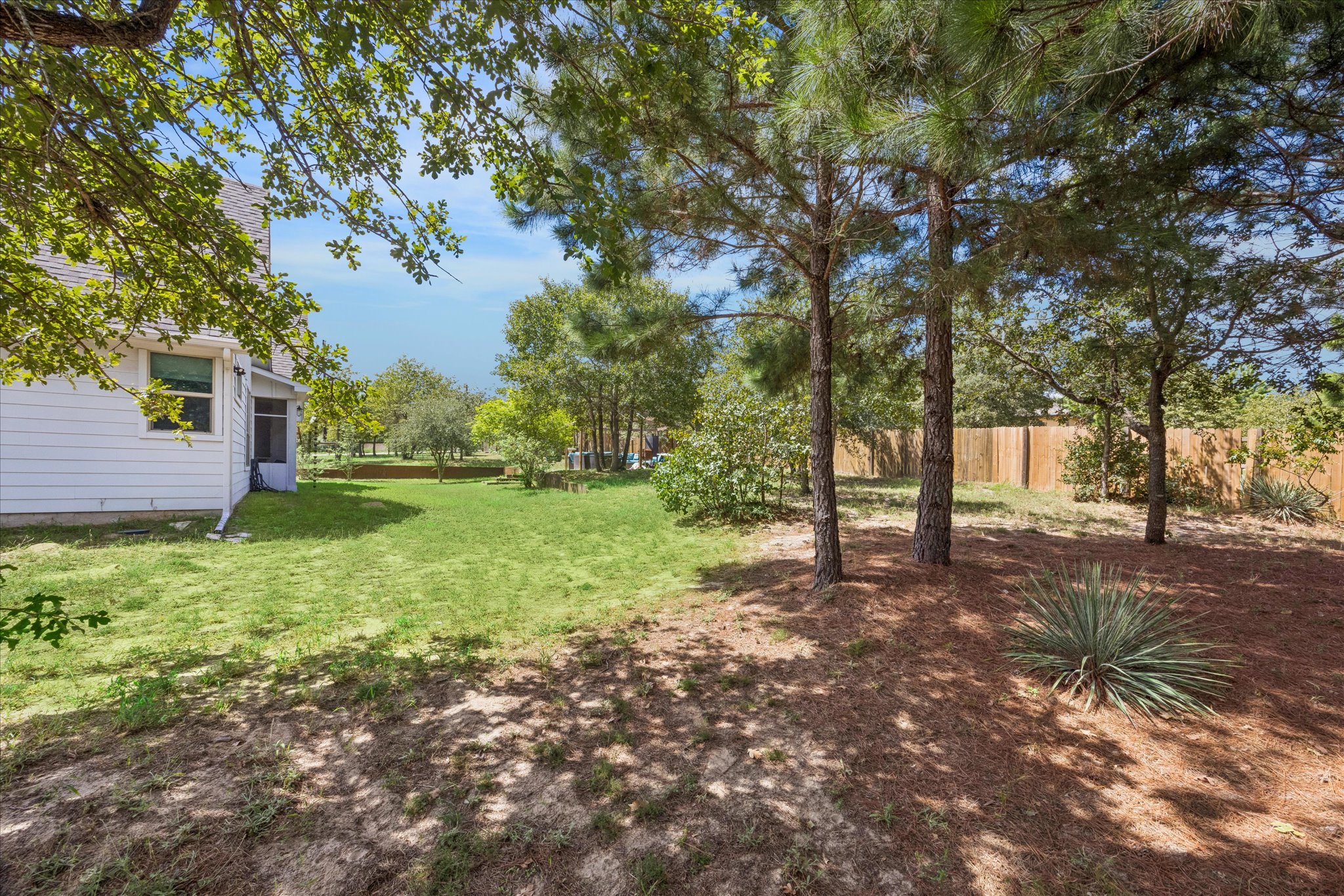 116 Mallard Road Bastrop, TX 78602 - Photo 30 of 31 Mature trees shade a spacious lawn bordered by a wood privacy fence.
