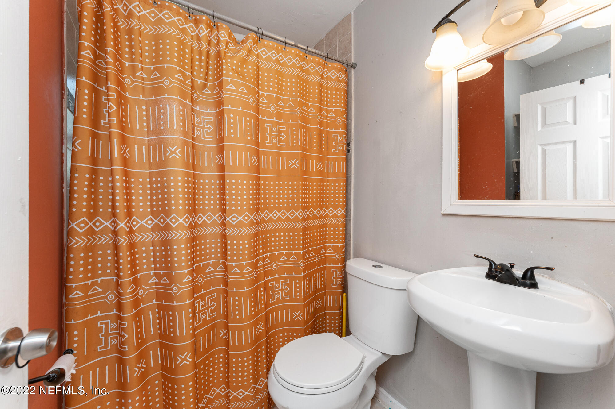 5015 Birkenhead Road Jacksonville, FL 32210 - Photo 13 of 17 a white toilet sitting next to a white sink and a shower curtain