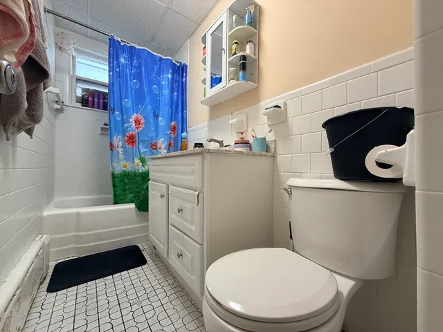 a bathroom with a toilet and a shower curtain