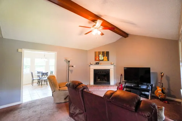 a living room with furniture a mirror and lamp