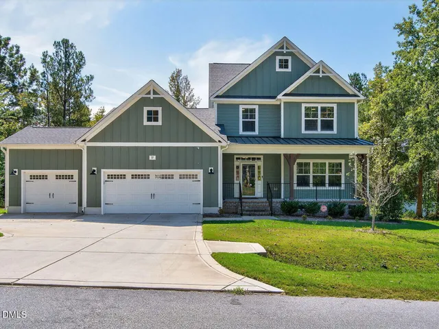a front view of a house with a yard and trees