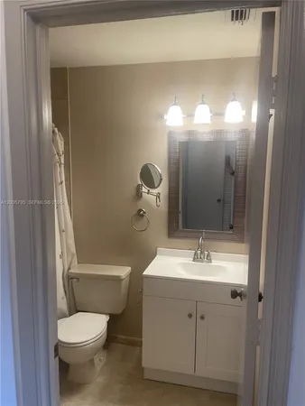 a bathroom with a toilet sink and mirror