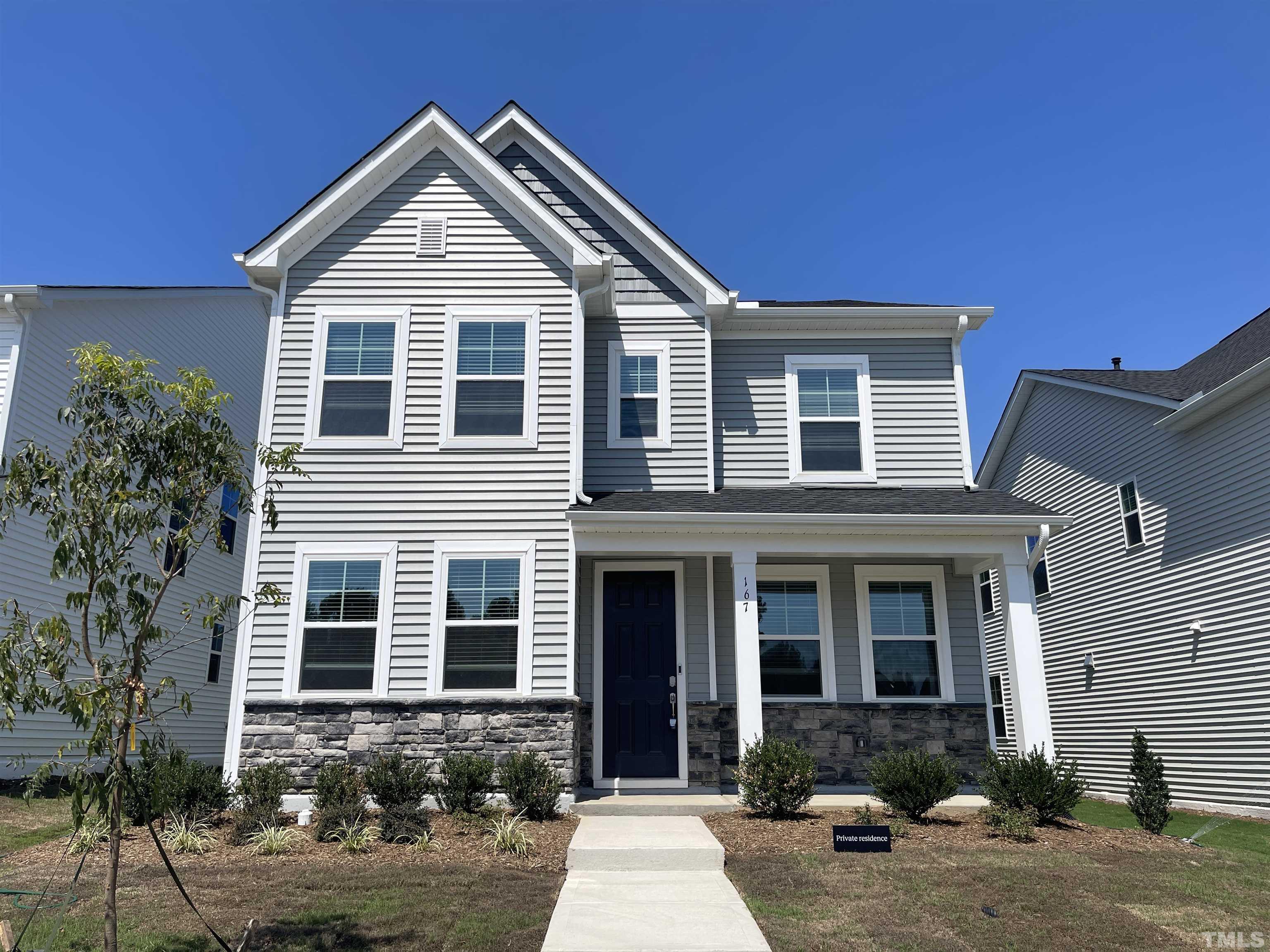 a front view of a house with yard and green space
