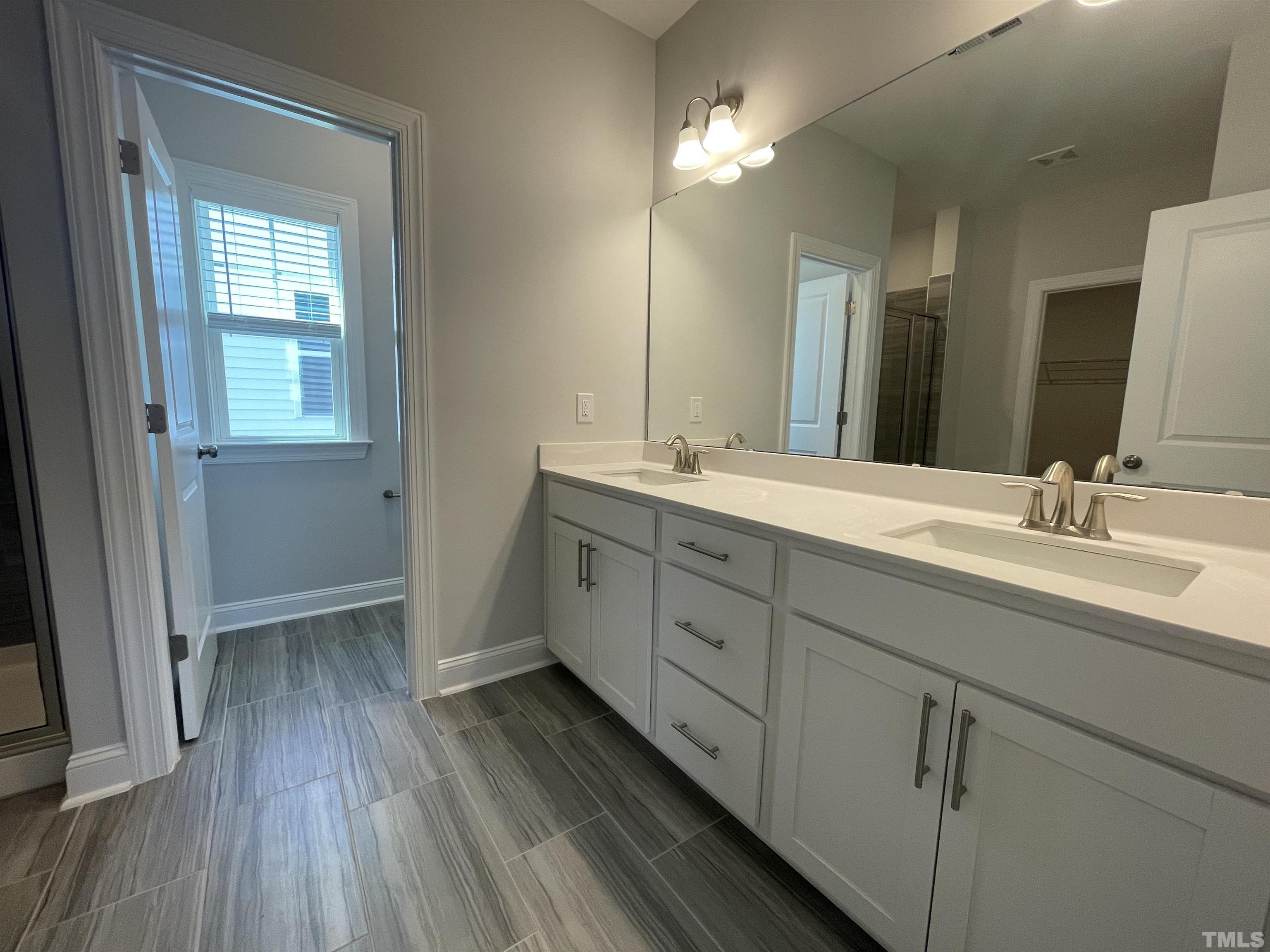 167 Edge Of Auburn Boulevard Clayton, NC 27520 - Photo 17 of 27 a spacious bathroom with a double vanity sink and mirror