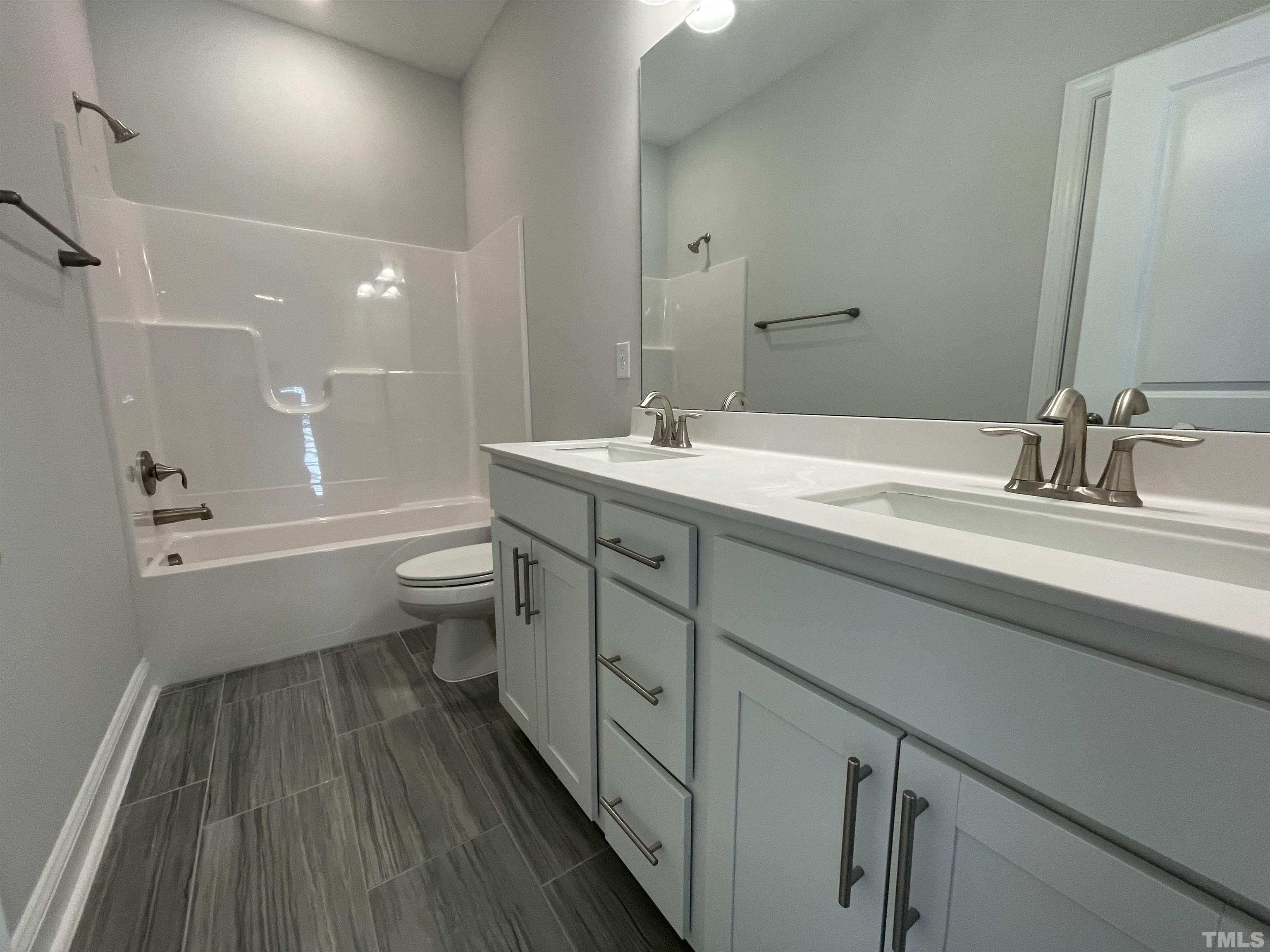 167 Edge Of Auburn Boulevard Clayton, NC 27520 - Photo 22 of 27 a bathroom with a double vanity sink toilet and a mirror