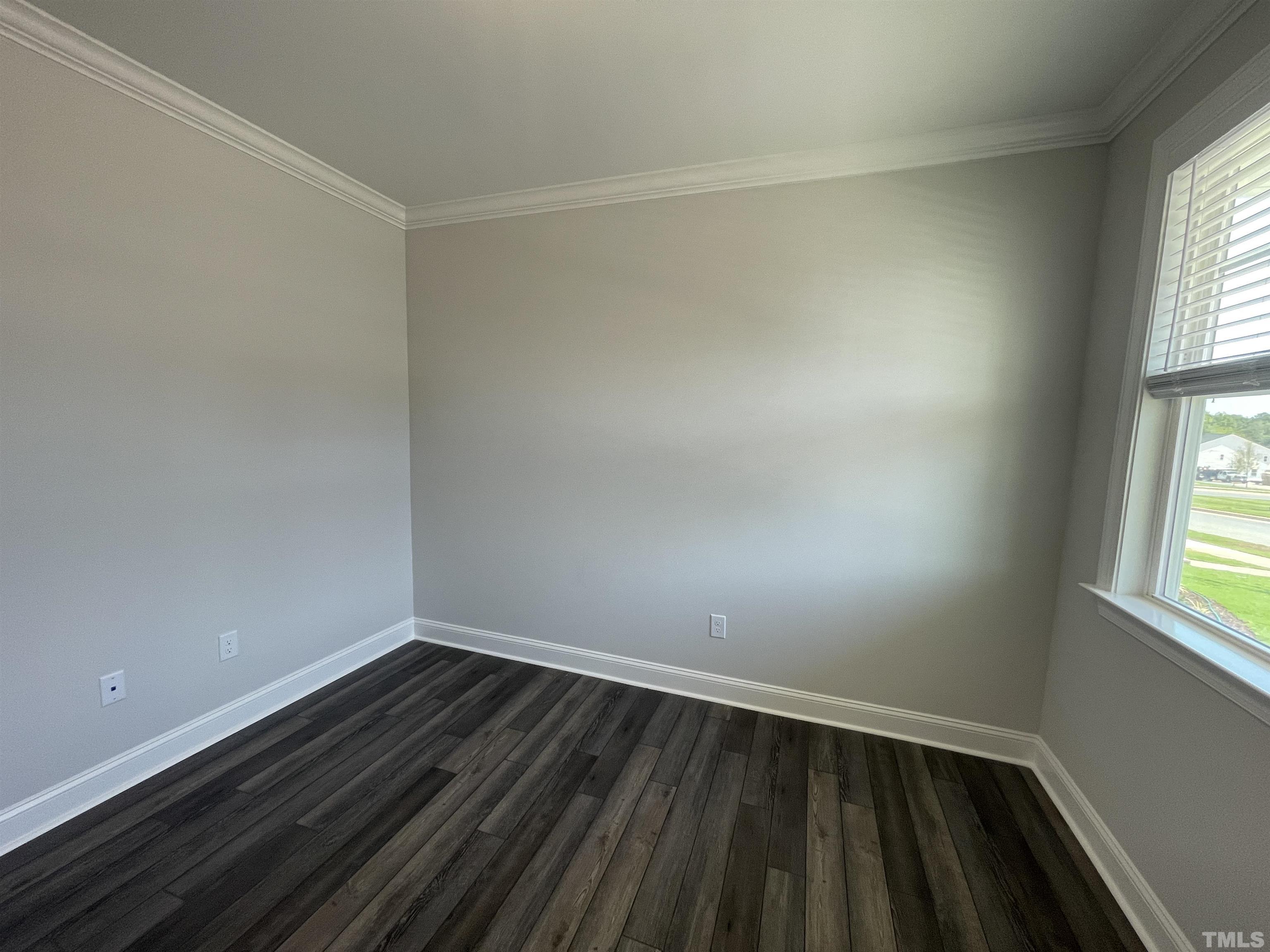 167 Edge Of Auburn Boulevard Clayton, NC 27520 - Photo 4 of 27 a view of an empty room with wooden floor and a window
