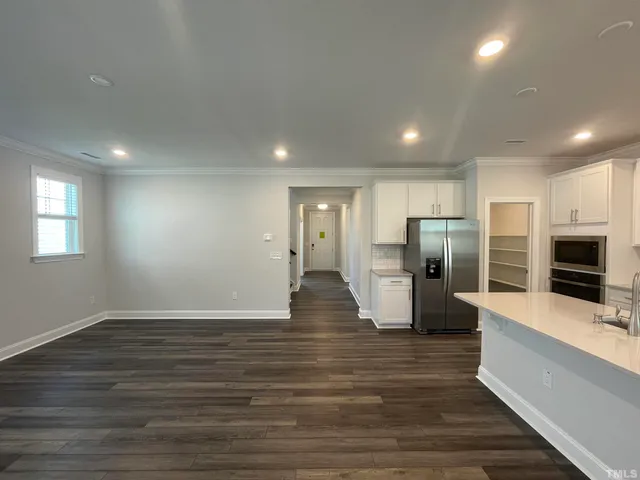 a view of a kitchen center island wooden floor and stainless steel appliances