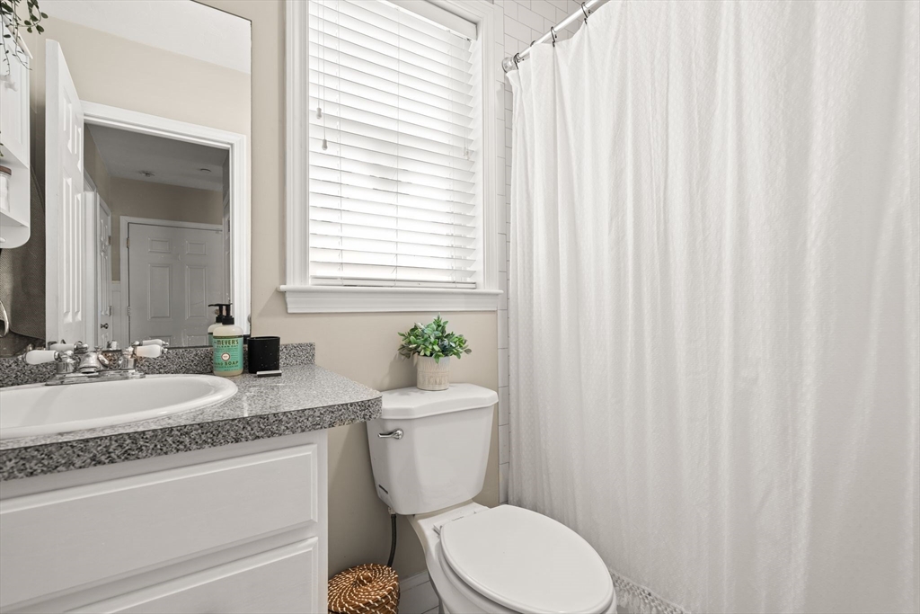 10 Malta Street, Unit 1 Hull, MA 02045 - Photo 13 of 17 a bathroom with a granite countertop toilet sink and mirror
