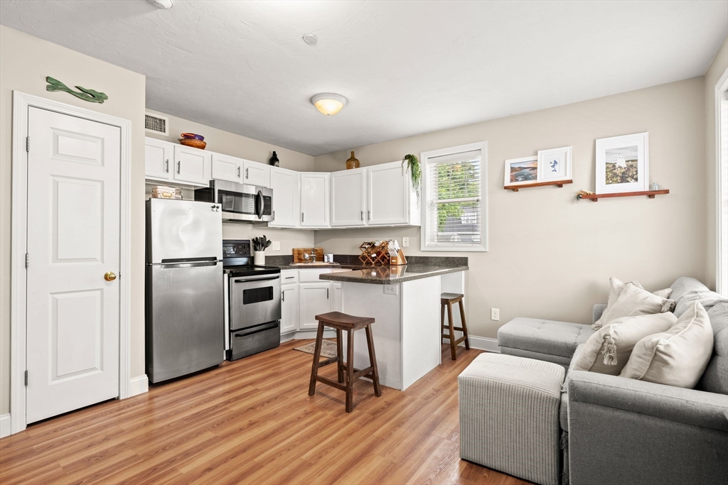 10 Malta Street, Unit 1 Hull, MA 02045 - Photo 9 of 17 a living room with stainless steel appliances furniture and a wooden floor