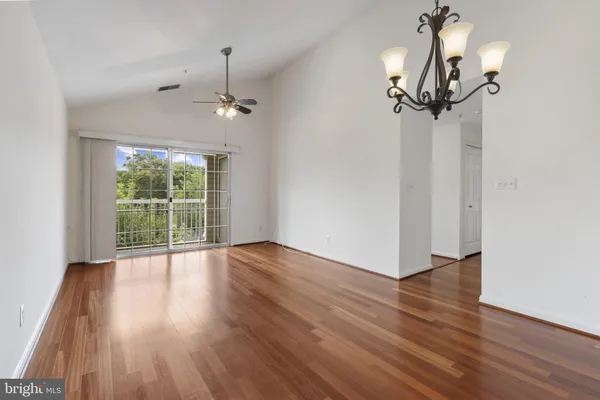 a view of a room with wooden floor and ceiling fan