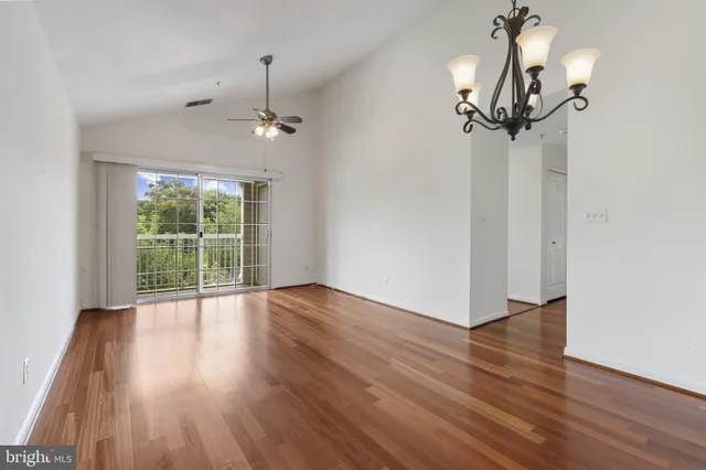 a view of a room with wooden floor and ceiling fan