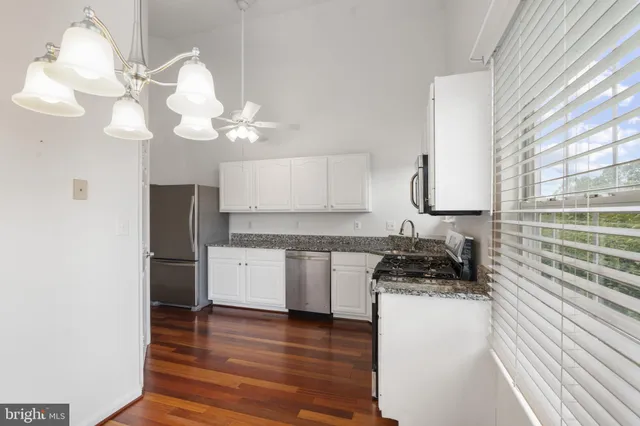 a kitchen with a refrigerator a stove and a window