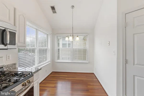 a view of a kitchen with a stove wooden floor and a kitchen