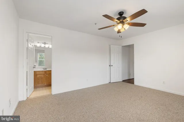 a view of an empty room with a chandelier fan