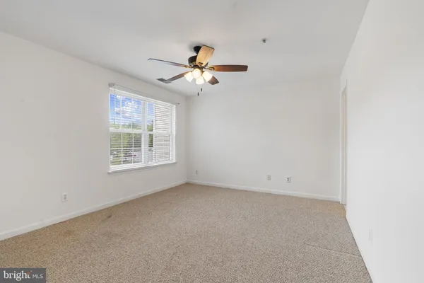 an empty room with a window and a fan