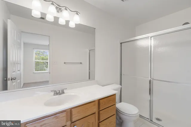 a bathroom with a sink vanity granite toilet and a mirror