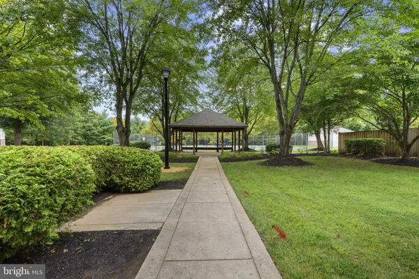 a view of a brick house with a big yard and large trees