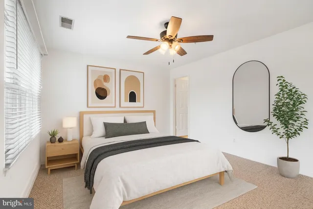 a bedroom with a bed and a potted plant