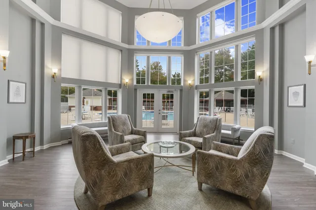 a living room with furniture a large window and wooden floor