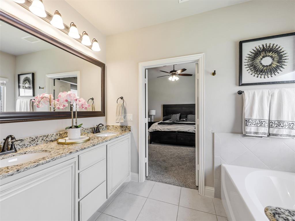 1216 Tree Shadow Lane Anna, TX 75409 - Photo 19 of 37 a en suite bathroom with a granite countertop sink and a mirror