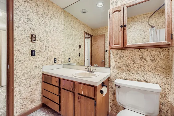 a bathroom with a granite countertop sink toilet and shower