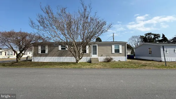 a view of a house with a big yard and large trees