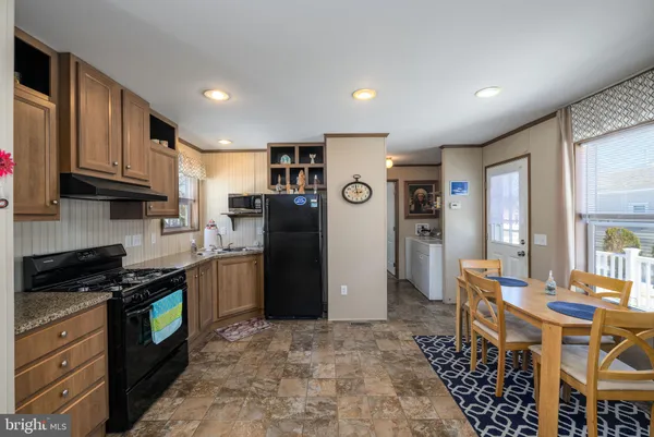a kitchen with granite countertop a refrigerator and a stove top oven