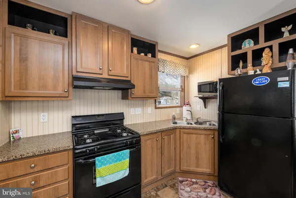 a kitchen with stainless steel appliances granite countertop a refrigerator stove and sink