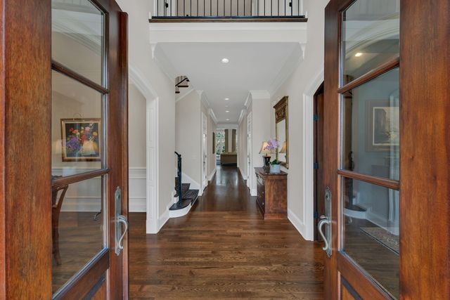 a view of a hallway with wooden floor and livingroom