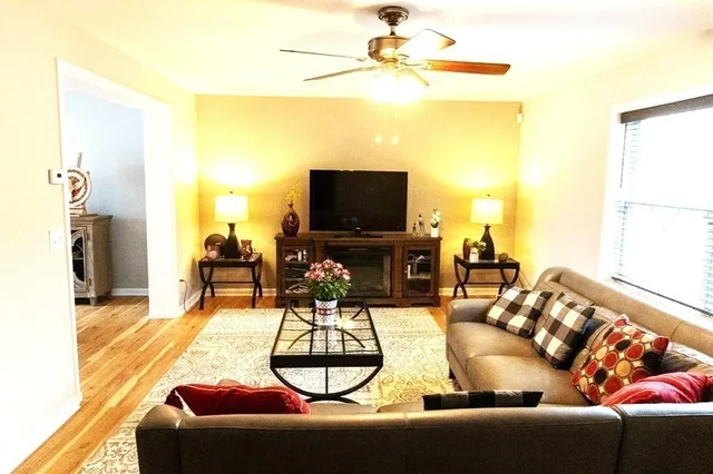 a living room with furniture a flat screen tv and a large window